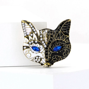 Dettaglio della spilla a maschera di volpe dorata con smalto e pietre blu brillanti