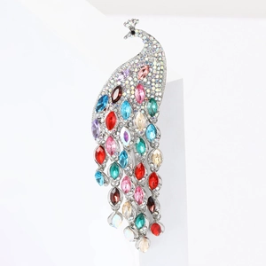 Détail macro d'une broche paon argentée sertie de strass multicolores et cristaux fins