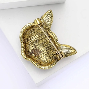 Dettaglio del retro della spilla maschera di volpe oro vintage con chiusura di sicurezza