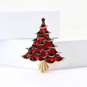 Détail de la broche sapin de Noël en émail rouge avec gemmes vertes et bordure dorée
