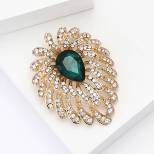 Exquisite gold fireworks brooch with pear-shaped green stone and white rhinestones