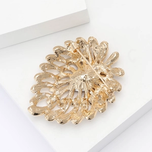 Detailed back view of gold flower brooch showing the secure pin fastener and hollow metal petals