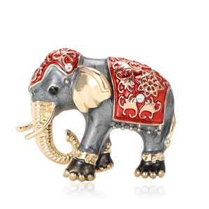 Vintage alloy elephant brooch with red enamel and gold details on white background