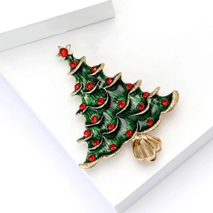 Élégante broche sapin de Noël en émail vert et strass rouges sur une base en métal doré