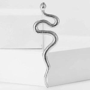 Détail de la broche serpent argentée avec texture d'écailles sur socle en pierre blanche