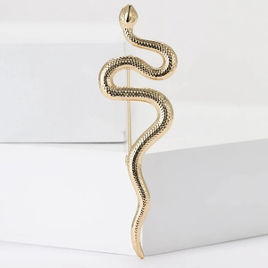 Élégante broche serpent plaquée or avec textures d'écailles sur socle blanc