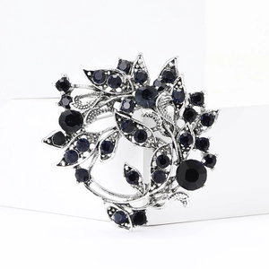 Detailed macro view of silver wreath brooch with sparkling dark blue rhinestones