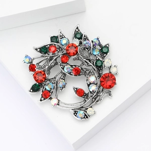 Elegant silver alloy flower wreath brooch with red and green rhinestones on white steps