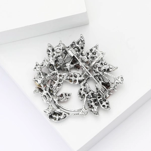 Detailed back view of vintage silver wreath brooch with safety pin and hollow metalwork