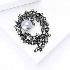 Vintage silver branch brooch with grey crystals and elegant pearl on white stand