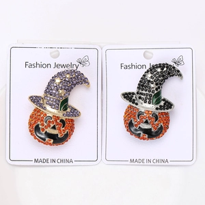 Detail of Halloween pumpkin wizard brooches with orange rhinestones on a jewelry card