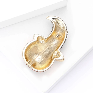 Detail view of the golden pumpkin brooch back featuring a secure pin clasp and metal finish