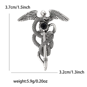Vue détaillée de la broche caducée ailes d'ange en émail avec finition argentée et pierre