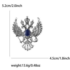 Detailed view of silver eagle brooch with a blue gemstone center and heraldic textures