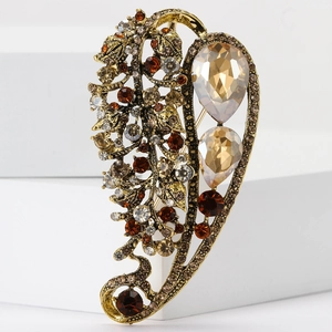 Detail of vintage gold alloy brooch with amber crystals and teardrop rhinestones