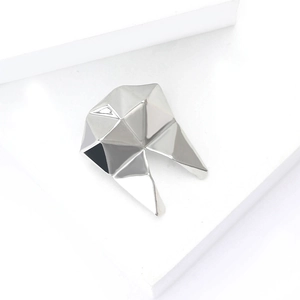 Macro shot of silver geometric faceted brooch with a sleek polished metallic finish