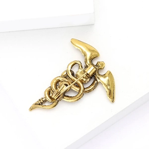Détail du revers de la broche caducée vintage avec fermoir de sécurité en métal robuste