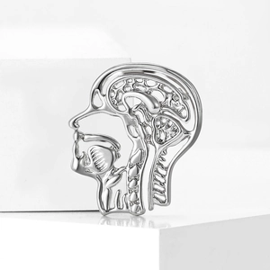 Macro detail of silver plated brain anatomy brooch showing intricate cutout metal texture