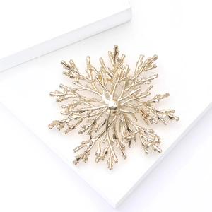 Detailed back view of golden snowflake brooch showing the secure pin fastener