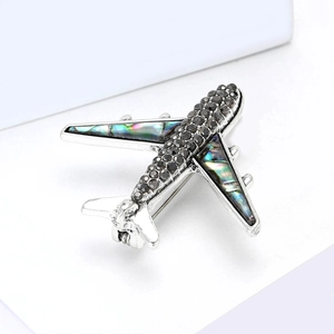 Broche avion moderne avec cristaux noirs et nacre d'abalone sur alliage d'argent poli