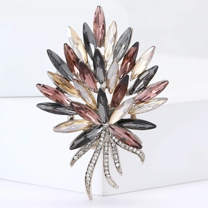 Detailed macro view of crystal torch brooch with smoky marquise rhinestones on white block