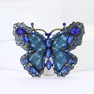 Detail shot of vintage gold butterfly brooch with blue rhinestones and crystal wings