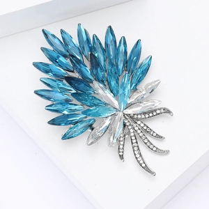 Close-up of elegant blue leaf brooch with crystal rhinestones and silver tassels