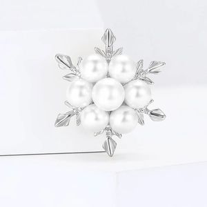 Broche flocon de neige minimaliste avec perles blanches et métal argenté sur bloc blanc