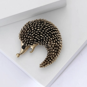Detailed close-up of a vintage bronze hedgehog brooch showing intricate alloy quill textures