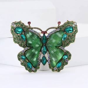 Detailed macro of a green crystal butterfly brooch on vintage bronze metal base