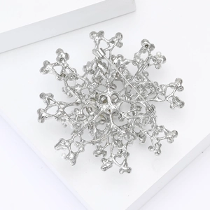 Detailed back view of a silver snowflake brooch showing the secure safety pin clasp