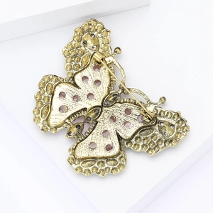 Detailed back view of a butterfly brooch showing the secure pin and antique gold finish