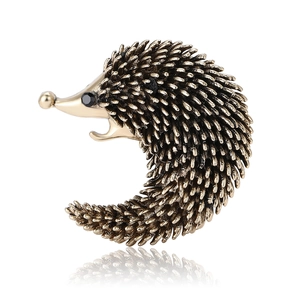 Vintage gold alloy hedgehog brooch with enamel details and black rhinestone eyes