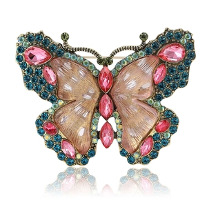 Vintage gold butterfly brooch with pink and teal rhinestones on white background