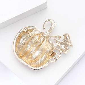 Detail view of the golden pumpkin brooch back featuring a secure alloy pin fastener