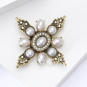 Detail shot of vintage baroque brooch with gold alloy pearls and sparkling rhinestones