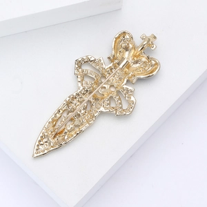 Detailed back view of a gold crown sword brooch showing the secure metal safety pin