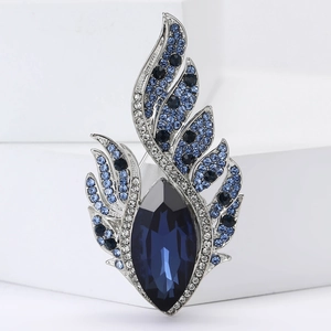 Elegant silver feather brooch featuring a large navy blue crystal and gradient rhinestones