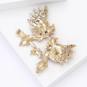 Detailed back view of a gold-plated bird brooch featuring a secure safety pin and smooth alloy finish