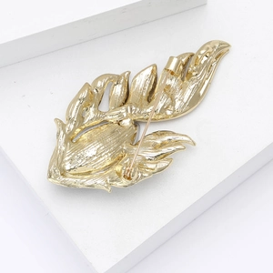 Macro detail of the alloy feather brooch back with secure pin clasp and gold mirror finish