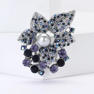 Détail macro d'une broche vintage en alliage avec cristaux violets et perle grise
