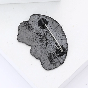 Close-up of the black alloy brain brooch back showing the metal pin and detailed texture
