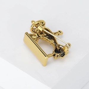 Detail view of the vintage sewing machine brooch showing the sturdy back pin clasp