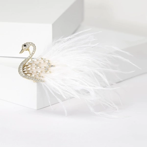 Detailed view of luxury swan brooch with white feathers and sparkling zircons
