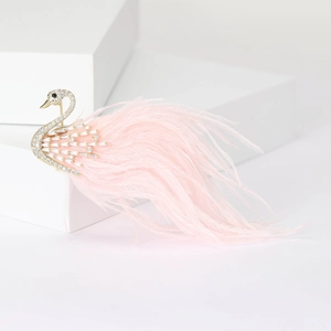 Detailed view of elegant gold swan brooch with white zircons and soft pink feathers
