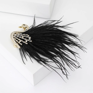Detailed view of swan brooch with black feathers and zircon stones on white step