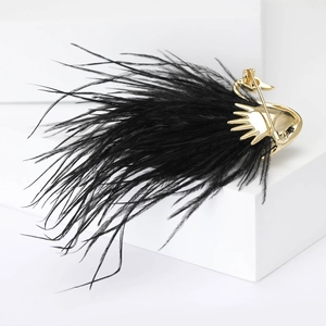 Detail of elegant black feather swan brooch with golden pin clasp on white background