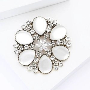 Macro detail of snowflake brooch with cat-eye stones and rhinestones on gold alloy base