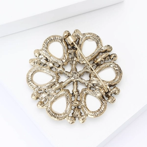Detail view showing the back metal pin structure of vintage gold hollowed-out brooch