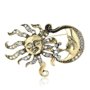 Broche vintage soleil et lune dorée avec strass colorés sur un fond blanc pur